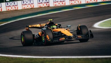Carro de fórmula laranja da equipe McLaren em curva na pista de corrida